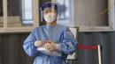 Pekerja medis mengenakan alat pelindung bersiap untuk mengambil sampel di klinik skrining sementara untuk virus corona di Seoul, Korea Selatan, Jumat (24/9/2021). Korea Selatan telah melaporkan lonjakan harian terbesar virus corona sejak dimulainya pandemi. (AP Photo/Lee Jin-man)