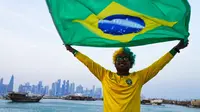 Penggemar timnas Brasil, Ajmal Pial dari Khulna, Bangladesh, mengibarkan bendera timnas kesayangannya di Doha, Qatar, Jumat (18/11/2022). Para penggemar membanjiri Qatar pada hari Jumat menjelang Piala Dunia pertama di Timur Tengah ketika tuan rumah memutuskan untuk melarang penjualan bir di stadion selama gelaran tersebut - dalam perubahan mengejutkan di menit-menit terakhir yang disambut oleh Muslim konservatif negara itu. (AP Photo/Jon Gambrell)