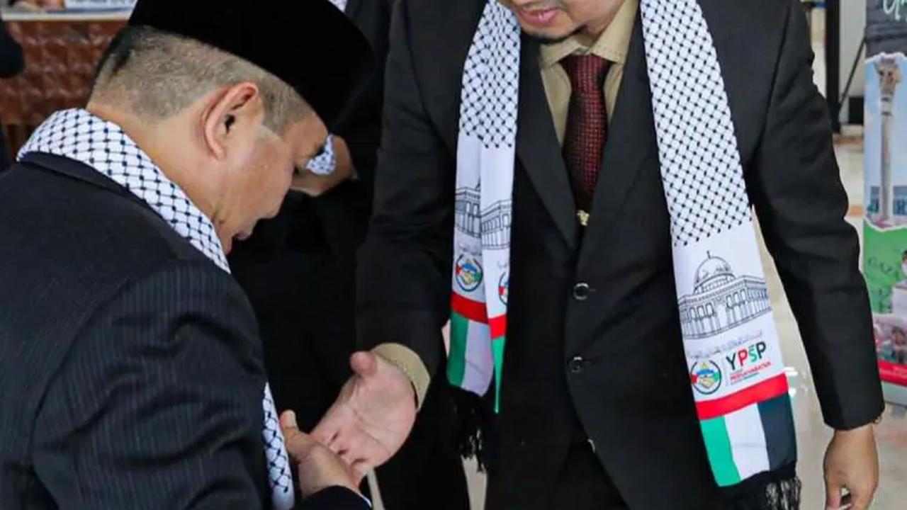 Pada ujung syal putih yang diberikan tersebut terdapat gambar bangunan Kubah Batu Yerusalem dan juga bendera Palestina.