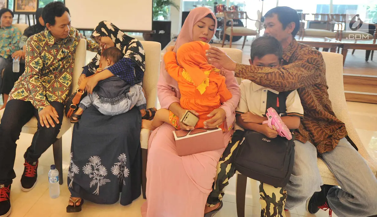 Dua orang ABK berbincang dengan keluarganya di Gedung Kemenlu, Jakarta (2/4). Kementerian Luar Negeri RI berhasil membebaskan enam anak buah kapal (ABK) asal Indonesia yang disandera di wilayah konflik Benghazi, di Libya. (Merdeka.com/Arie Basuki)