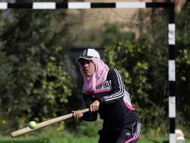 Seorang wanita Palestina memukul bola saat mengikuti sesi latihan bisbol di Khan Younis, Jalur Gaza, 19 Maret 2017. Sekelompok wanita muda muslim mencoba olahraga bisbol sebagai hiburan. (AP Photo/Khalil Hamra)