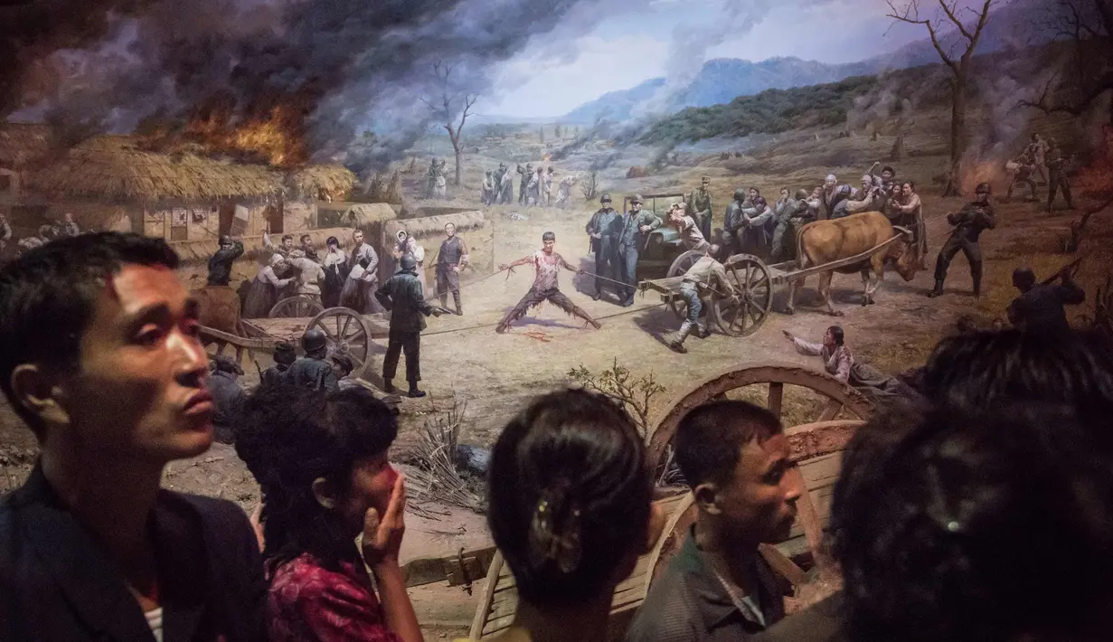 Pengunjung melihat lukisan tentara AS menyiksa seorang pria Korea Utara di Sinchon Museum of American War Atrocities di Pyongyang 24 Juli 2017. Pada Juli 2015, museum ini dibangun ulang dan dipindahkan ke sebuah lokasi baru. (AFP Photo/Ed Jones)