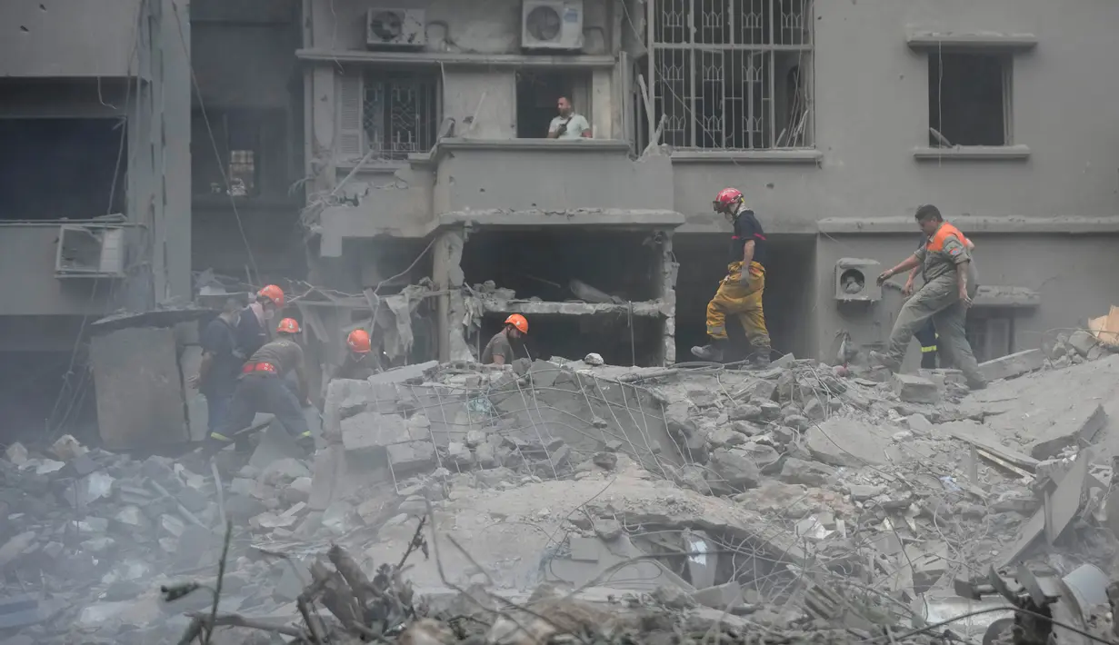 Petugas penyelamat memindahkan puing-puing bangunan yang hancur, saat mereka mencari korban di lokasi serangan udara Israel hari Kamis (10/10), di Beirut, Lebanon, Jumat, 11 Oktober 2024. (AP Photo/Hussein Malla)