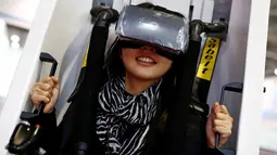 Seorang wanita duduk di VR Capsule mencoba simulator maya pada Konferensi Robot Dunia WRC 2016 di Beijing, Tiongkok (21/10). Rangkaian acara ini terdiri dari pameran, forum, dan kontes robot. (Reuters/Thomas Peter)