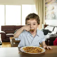 Potret anak yang sedang melahap makanannya/copyright freepik.com/rawpixel.com