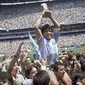 Diego Maradona memegang trofi timnya setelah Argentina menang 3-2 atas Jerman Barat pada pertandingan final Piala Dunia di Stadion Azteca di Mexico City. Maradona meninggal karena serangan jantung pada Rabu, 25 November 2020, di rumahnya di Buenos. Aires.