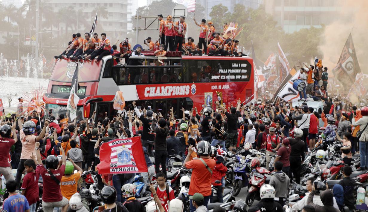 Pemain Persija Jakarta bersama The Jakmania melakukan pawai merayakan gelar Piala Liga 1 musim 2018 di Bundaran HI, Jakarta, Sabtu (15/12). Persija berhasil juara Liga 1 usai mengalahkan Mitra Kukar. (Bola.com/Yoppy Renato)