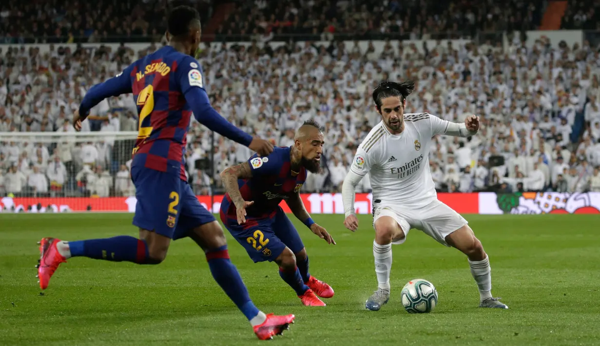 Gelandang Real Madrid, Isco berebut bola dengan pemain Barcelona, Arturo Vidal dan Nelson Semedo pada lanjutan pertandingan La Liga di Santiago Bernabeu, Minggu (2/3/2020).  Real Madrid membungkam Barcelona 2-0 dan merebut puncak klasemen dari Barcelona. (AP/Andrea Comas)
