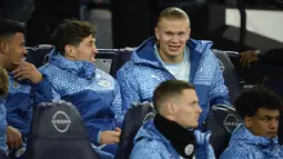 Striker Manchester City, Erling Haaland duduk di bangku cadangan bersama rekan setimnya saat menghadapi Aston Villa pada laga pekan ke-31 Premier League 2023/2024 di Etihad Stadium, Manchester, Rabu (3/4/2024) malam. (AP Photo/Dave Thompson)