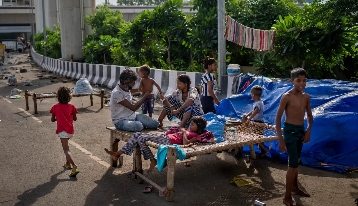 Bersama anak-anak dan suami, Rekha Devi mengungsi ketika hujan monsun yang mencapai rekor pada bulan Juli lalu. (AP Photo/Altaf Qadri)