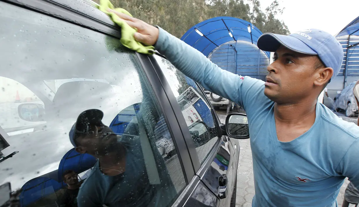 Seorang imigran asal Kuba saat membersihkan sebuah mobil di tempat pencucian mobil, Quito, Ekuador ,Selasa (1/12). Pemerintah Ekuador mengumumkan bahwa warga Kuba yang berada di Ekuador wajib mempunyai Visa. (REUTERS/Guillermo Granja)