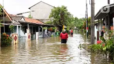 Warga melintasi genangan air di salah satu permukiman di kawasan Cakung, Jakarta Timur, Rabu (29/1/2025). (Liputan6.com/Herman Zakharia)