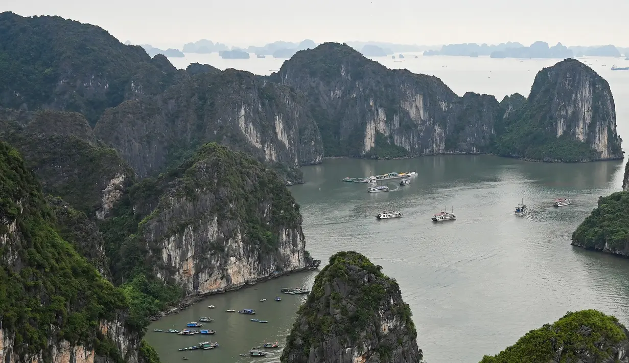 Kapal-kapal wisata berlayar di perairan Ha Long Bay, Provinsi Quang Ninh, Vietnam, Jumat (10/5/2019). Destinasi wisata yang terletak di Teluk Tonkin ini menjadi ikon yang cukup populer di Vietnam. (Manan VATSYAYANA/AFP)