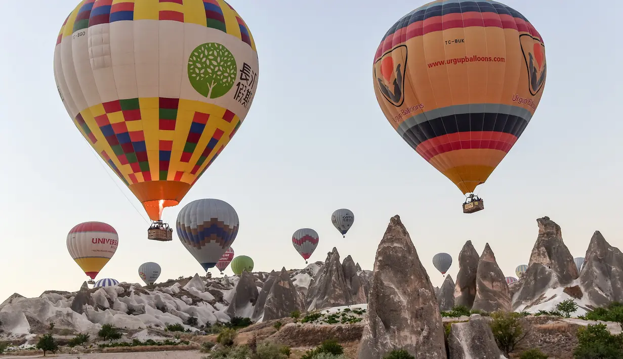 <p>Sejumlah balon udara panas yang membawa wisatawan terbang di atas Nevsehir di wilayah Cappadocia, Turki (5/9). (AFP Photo/Yasin Akgul)</p>