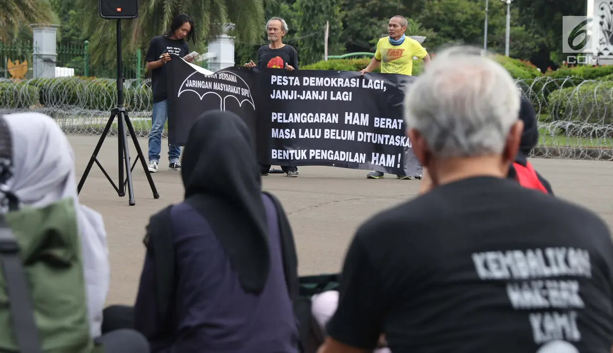 Peserta melakukan refleksi Kamisan ke-571 di kawasan Silang Barat Laut Monas, Jakarta, Kamis (24/1). Dalam aksi Kamisan ke-571, JSKK mengeluarkan surat terbuka meminta NKRI jangan dijadikan negara impunitas. (Liputan6.com/Helmi Fithriansyah)