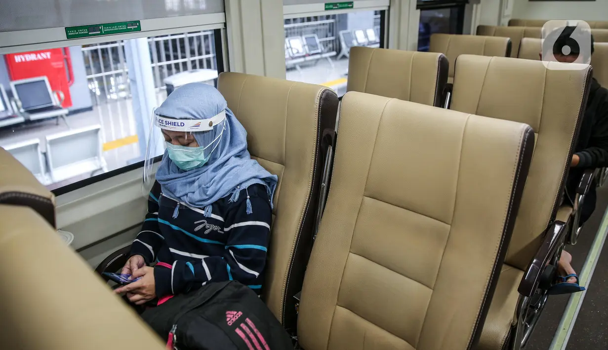 Penumpang menggunakan pelindung wajah berada di kereta jarak jauh di Stasiun Pasar Senen, Jakarta Pusat, Jumat (10/7/2020). PT. KAI membagikan face shield kepada penumpang bertujuan memudahkan masyarakat tetap dapat menjaga physical distancing di tengah pandemi COVID-19. (Liputan6.com/Faizal Fanani)