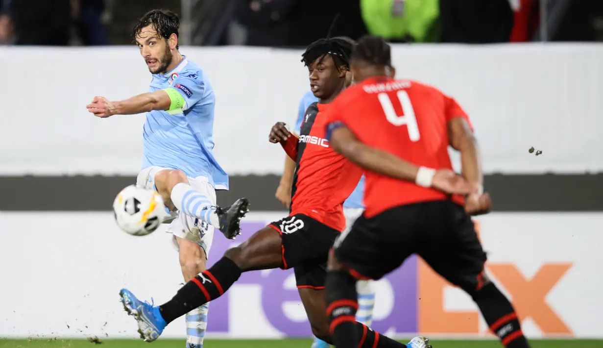 Pemain Lazio Marco Parolo (kiri) menendang bola saat menghadapi Rennes pada pertandingan Grup E Liga Europa di Stadion Roazhon Park, Rennes, Prancis, Kamis (12/12/2019). Lazio gagal lolos ke 32 besar Liga Europa setelah kalah dari Rennes 2-0. (AP Photo/David Vincent)