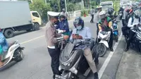 Petugas saat melakukan pemeriksaan kartu vaksin terhadap pengendara motor di Jalan Trans Sulawesi (Arfandi Ibrahim/Liputan6.com)
