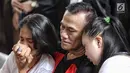 Aktor Tio Pakusadewo merangkul sang anak, Risa (kiri) dan keponakannya, Namira saat menunggu sidang  kasus penyalahgunaan narkoba di Pengadilan Negeri Jakarta Selatan, Kamis (28/6). Sidang beragenda pembacaan pledoi oleh Tio. (Liputan6.com/Faizal Fanani)
