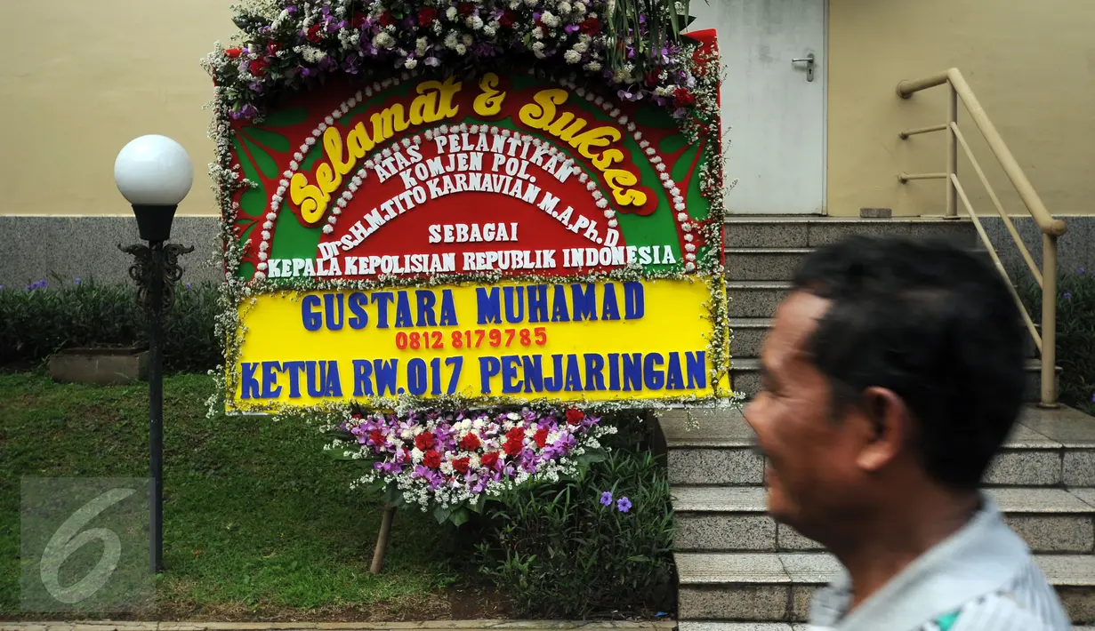 Pekerja melintas di depan karangan bunga ucapan selamat dilantiknya Komjen Pol Tito Karnavian di Mabes Polri, Jakarta, Rabu (13/7). Tito Karnavian akan dilantik menjadi Kapolri di Istana Negara oleh Presiden Jokowi. (Liputan6.com/Helmi Fithriansyah)