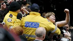 Pengunjuk rasa memberontak saat akan ditangkap polisi, Kanada (24/3). Wanita tersebut berunjuk rasa karena menilai putusan hakim tidak adil kepada terduga pelecehan seksual. (Reuters/Mark Blinch)