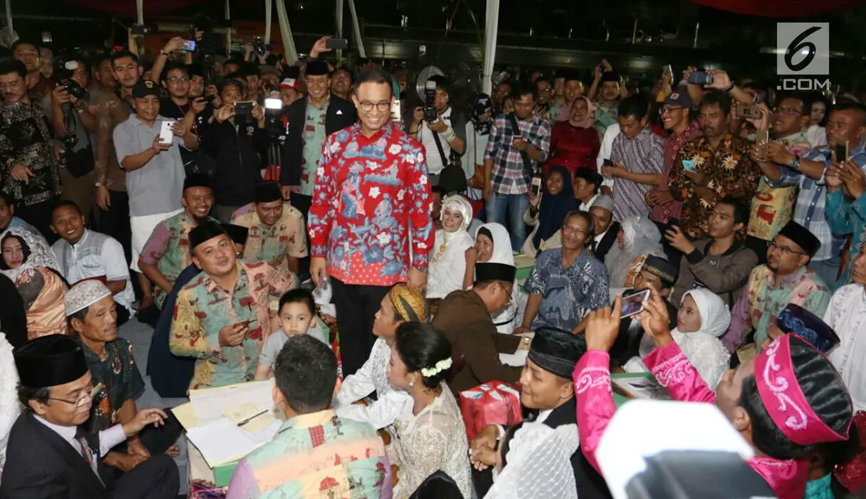 Gubernur DKI Jakarta, Anies Baswedan saat meninjau nikah massal di malam pergantian tahun di Jalan MH Thamrin, Jakarta, Minggu (31/12).  Sebanyak 430 pasangan melakukan nikah massal melalui seleksi oleh pemprov DKI Jakarta. (Liputan6.com/Angga Yuniar)