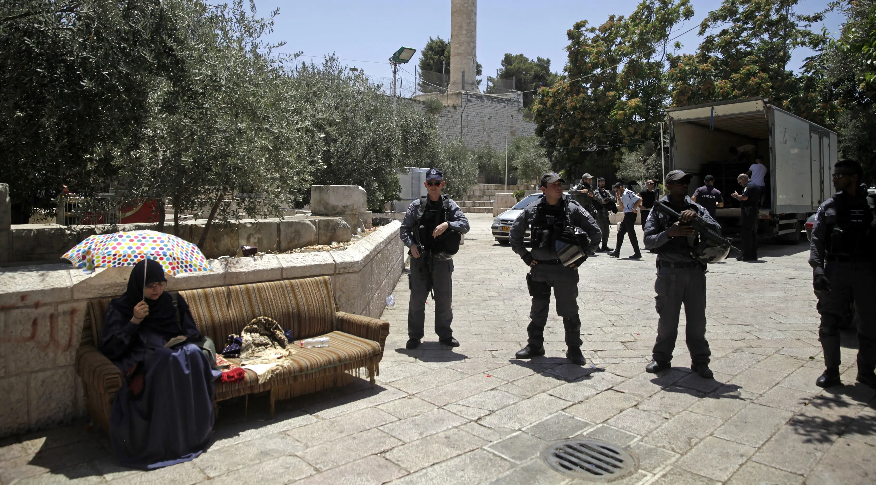 Petugas Israel melakukan penjagaan terhadap wanita muslim yang duduk di luar komplek Masjid Al- Aqsa, Yerusalem, Minggu (16/7). Setelah pekan lalu terjadi kerusuhan antara warga Arab-Israel dengan petugas kepolisian Israel. (AP/Mahmoud Illean)