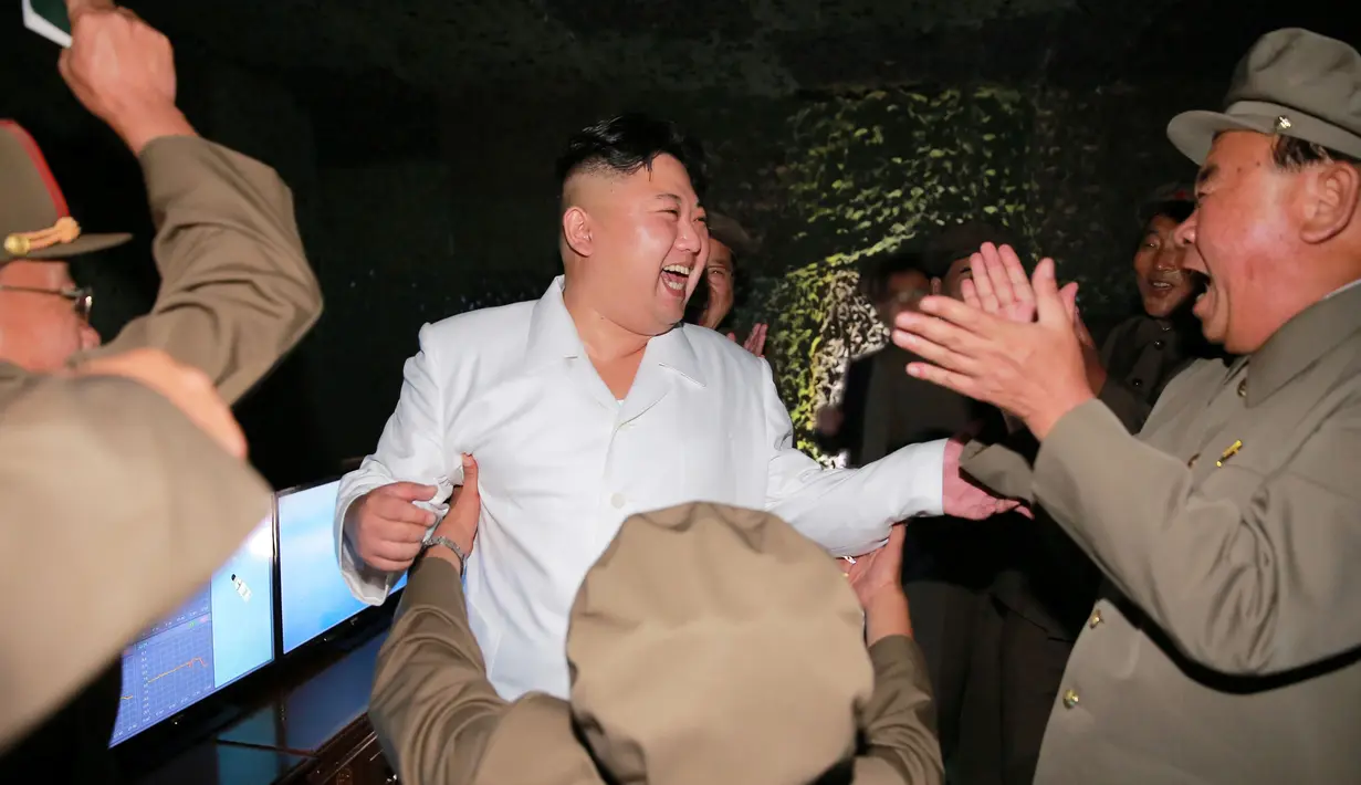 Tawa bahagia Kim Jong-un saat tes tembakan rudal balistik dari kapal selam, Pyongyang (25/8). Seorang pejabat AS mengatakan rudal tersebut melesat hingga 500 kilometer sebelum jatuh ke laut Jepang. (REUTERS/KCNA)