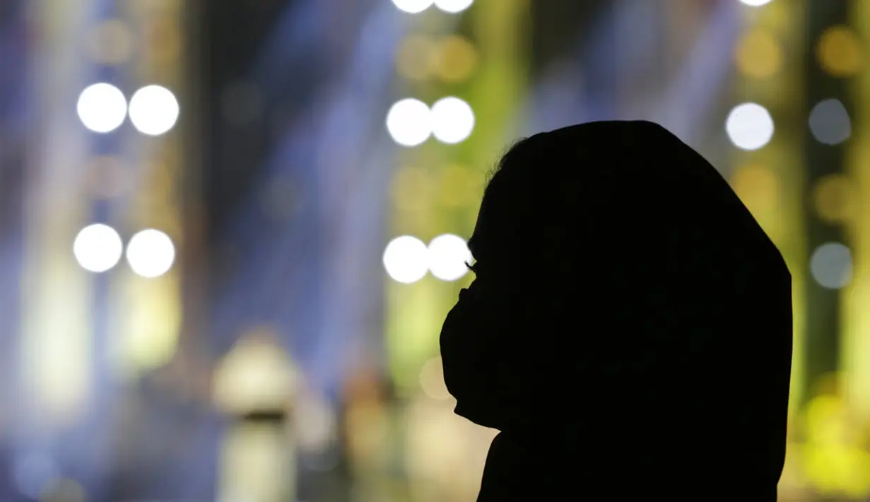 Seorang wanita mengenakan masker untuk membantu mencegah penyebaran virus corona mendengarkan penyanyi terkemuka Saudi Mohammed Abdu saat ia tampil di Super Dome yang baru dibangun, di Jiddah, Arab Saudi (8/7/2021). (AP Photo/Amr Nabil)
