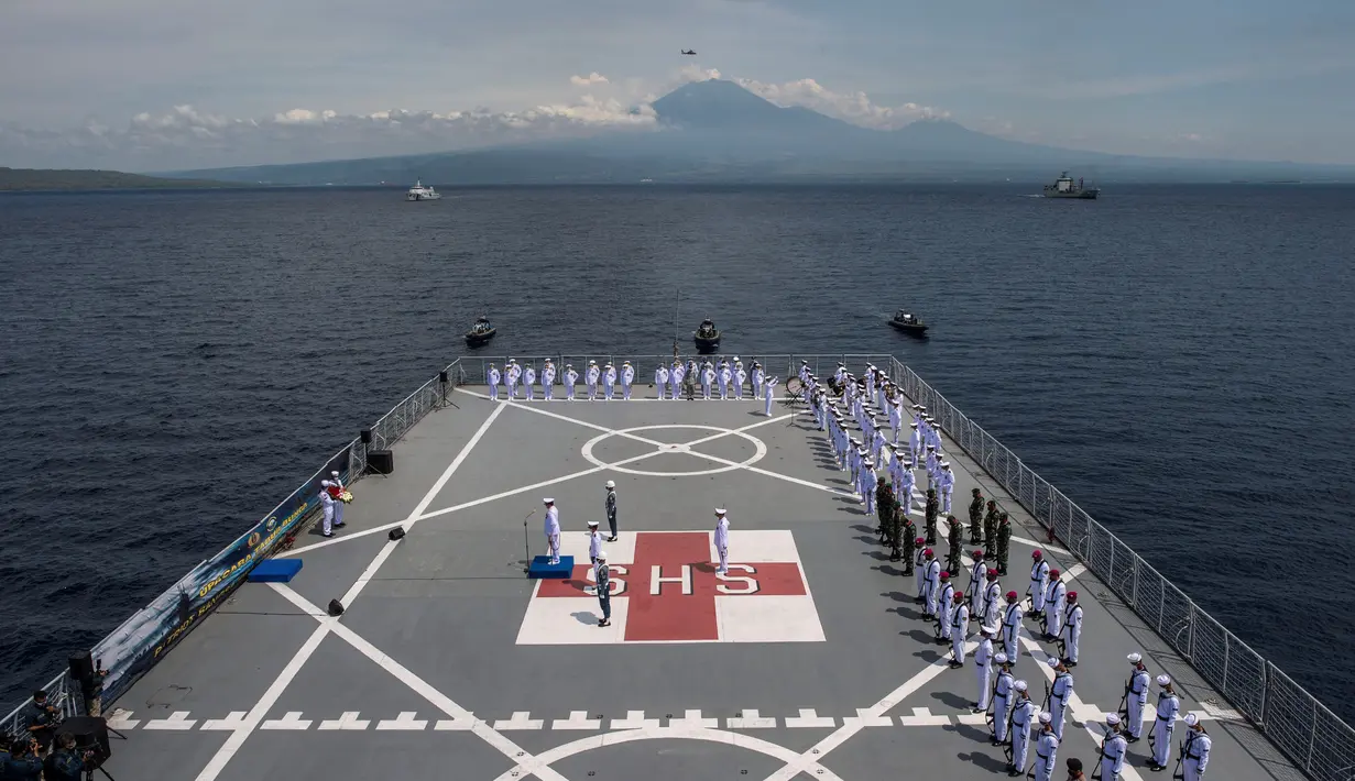 Prajurit TNI menggelar Upacara Tabur Bunga di geladak heli KRI Dr. Soeharso-990 di perairan utara Pulau Bali , Jawa Timur, Jumat (30/4/2021). Upacara itu digelar sebagai penghormatan terakhir bagi awak KRI Nanggala 402 yang gugur dalam medan tugas. (Juni Kriswanto/AFP)
