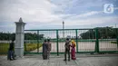 Warga berfoto di belakang Monumen Nasional atau Monas di Jakarta, Jumat (1/1/2021). Selain Monas, Taman Margasatwa Ragunan juga ditutup saat libur Tahun Baru. (Liputan6.com/Faizal Fanani)