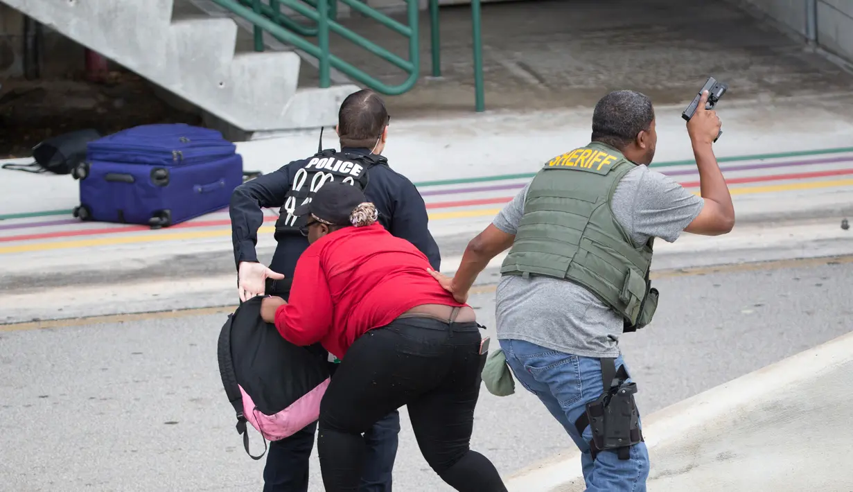 Aksi polisi saat memburu pelaku penembakan di Bandara Fort Lauderdale, Florida, AS (6/1). Pelaku dilaporkan bernama Esteban Santiago, 26 tahun, tercatat sebagai anggota militer Army National Guard, di San Juan sembilan tahun lalu. (AP Photo/Wilfredo Lee)