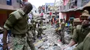 Petugas saat mencari korban yang terperangkap dalam reruntuhan bangunan yang ambruk di Nairobi, Kenya (30/4).Bangunan tersebut ambruk akibat hujan dan banjir yang menerpa kawasan Nairobi.( REUTERS/Harman Kariuki)