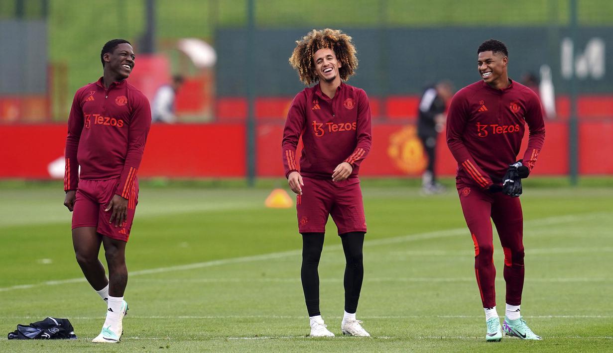 Pemain Manchester United, Kobbie Mainoo, Hannibal Mejbri dan Marcus Rashford tertawa bersama saat sesi latihan di Carrington Training Complex, Senin (23/10/2023). (AP/Nick Potts)