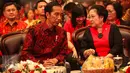 Presiden Jokowi dan Ketum PDIP Megawati Soekarnoputri berbincang disela peringatan HUT PDIP ke-44 di Jakarta Convention Center (JCC), Jakarta Pusat, Selasa (10/1). Sederet tokoh politik dan ketua partai hadir dalam acara itu. (Liputan6.com/Faizal Fanani)