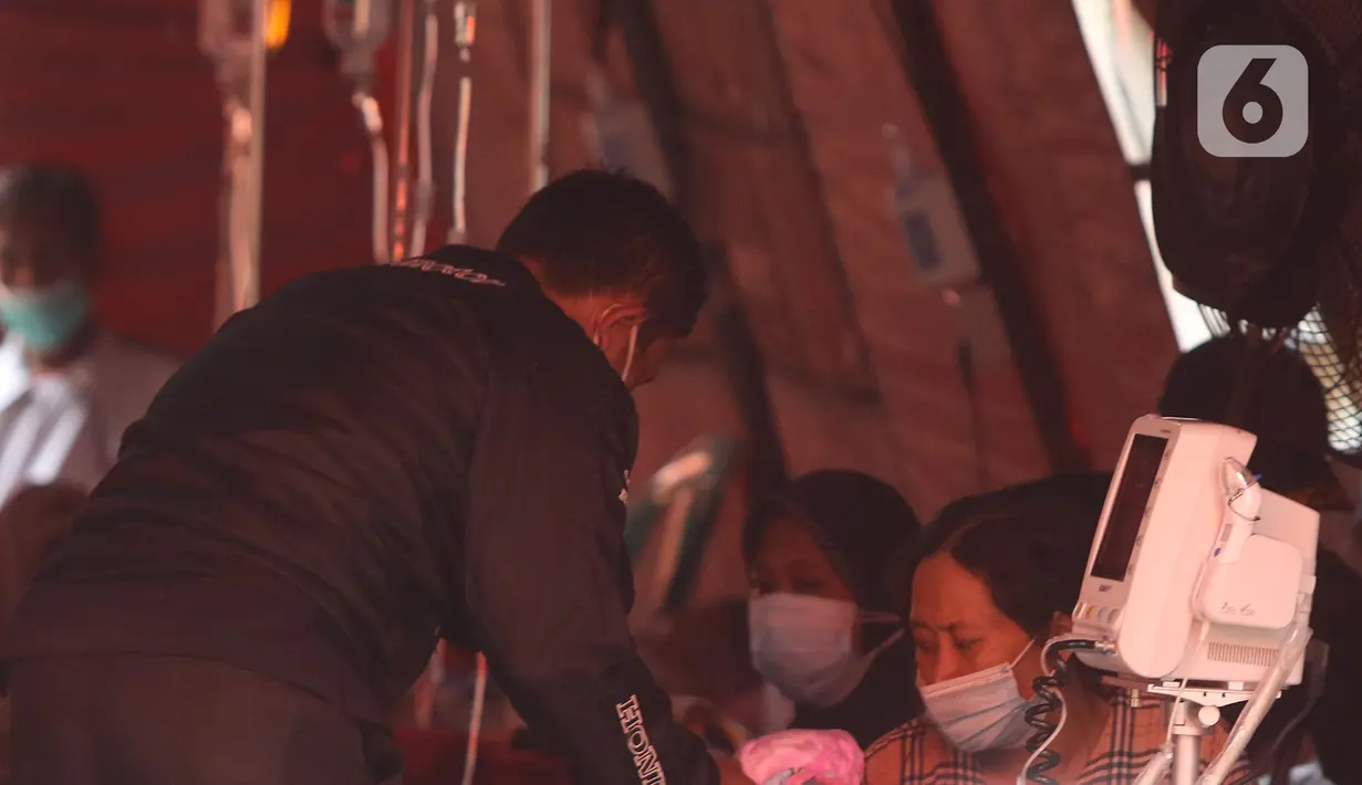 Pasien COVID-19 berada di dalam tenda darurat di RSUD Bekasi, Rabu (23/6/2021). Tenda darurat didirikan sebagai upaya menambah ruang IGD (Instalasi Gawat Darurat) yang dapat menampung 30 pasien menyusul ruangan di rumah sakit sudah penuh akibat lonjakan kasus Covid-19. (Liputan6.com/Herman Zakharia)
