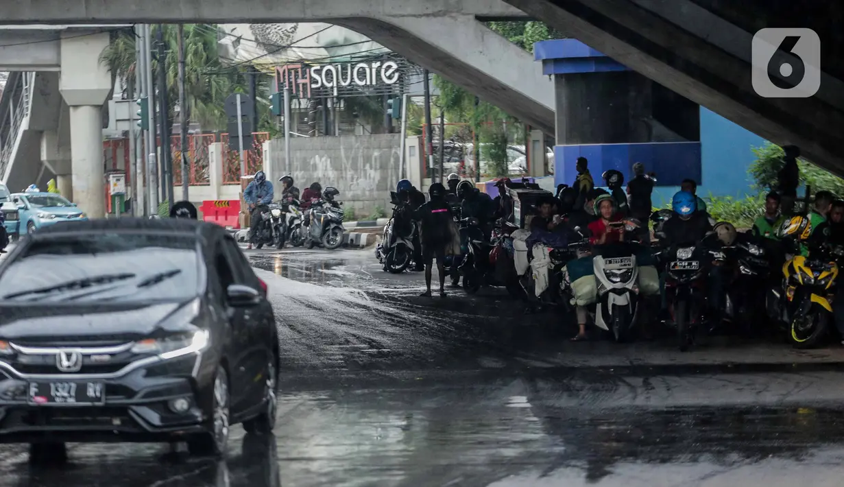 Pengendara sepeda motor memenuhi ruas jalan ketika berteduh di kolong Fly Over Cawang, Jakarta, Selasa (17/12/2019). Perilaku tersebut selain menimbulkan ketidaknyamanan pengguna jalan lainnya, juga memicu kemacetan. (Liputan6.com/Faizal Fanani)