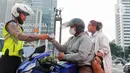 Polisi melakukan penindakan sanksi tilang kepada pengendara motor yang melakukan pelanggaran di Bundaran Hotel Indonesia (HI), Jakarta, Senin (15/5/2023). (Liputan6.com/Angga Yuniar)
