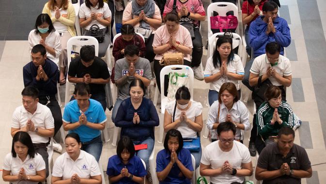 Orang-orang berdoa saat upacara pembukaan kembali pusat perbelanjaan Terminal 21 usai penembakan massal di Nakhon Ratchasima, Thailand, Kamis (13/2/2020). Sebelumnya, seorang tentara yang mengamuk melepaskan tembakan di mal tersebut hingga menewaskan 29 orang. (AP Photo/Sakchai Lalit)
