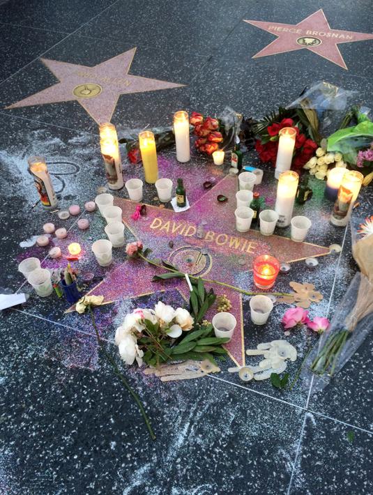Lilin dan bunga diletakkan di atas nama penyanyi legendaris David Bowie di Hollywood Walk of Fame di Los Angeles, Senin (11/1). Bowie meninggal di usianya yang ke 69 tahun dan baru saja merilis album ke-25 nya yaitu "Blackstar". (REUTERS/ Aron Ranen)
