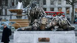 Warga saat melintasi patung singa di Trafalgar Square, London, Inggris, (28/1).   Alasan pemasangan patung ini yaitu untuk menyoroti ancaman terhadap singa yang mulai terancam punah. (REUTERS / Stefan Wermuth)