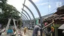 Pekerja menyelesaikan pembangunan revitalisasi Jembatan Cibubur, Jakarta, Senin (24/10/2022). Jembatan Cibubur yang saat ini sedang direvitalisasi, akan dilengkapi akses untuk pejalan kaki. Jembatan Cibubur yang menghubungkan Pasar Rebo dan Ciracas itu akan ditinggikan guna menghindari genangan ketika permukaan Kali Cipinang meninggi dan ditargetkan selesai pada bulan November 2022. (Liputan6.com/Faizal Fanani)