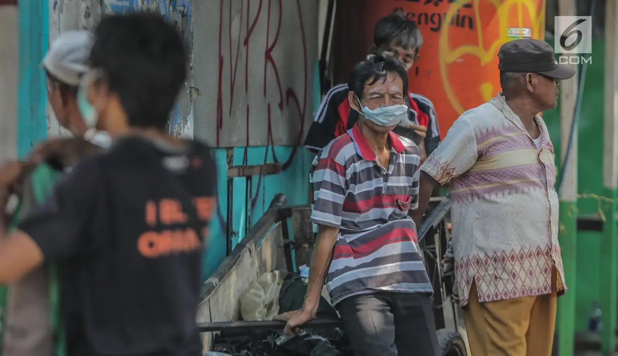 Warga memakai masker dan odol di wajah untuk menghindari sisa gas air mata pasca bentrok massa dengan aparat di Palmerah, Jakarta, Kamis (26/9/2019). Banyak masyarakat yang melintas dan warga sekitar perih pada mata hingga bersin akibat sisa gas air mata. (Liputan6.com/Faizal Fanani)