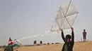 Warga Palestina bersiap menerbangkan layang-layang yang telah diberikan bom molotov di atas pagar perbatasan dengan Israel, di pinggiran timur Kota Gaza (20/4). Unjuk rasa warga Palestina terhadap Isrel memasuki minggu keempat. (AFP Photo/Mohammed Abed)