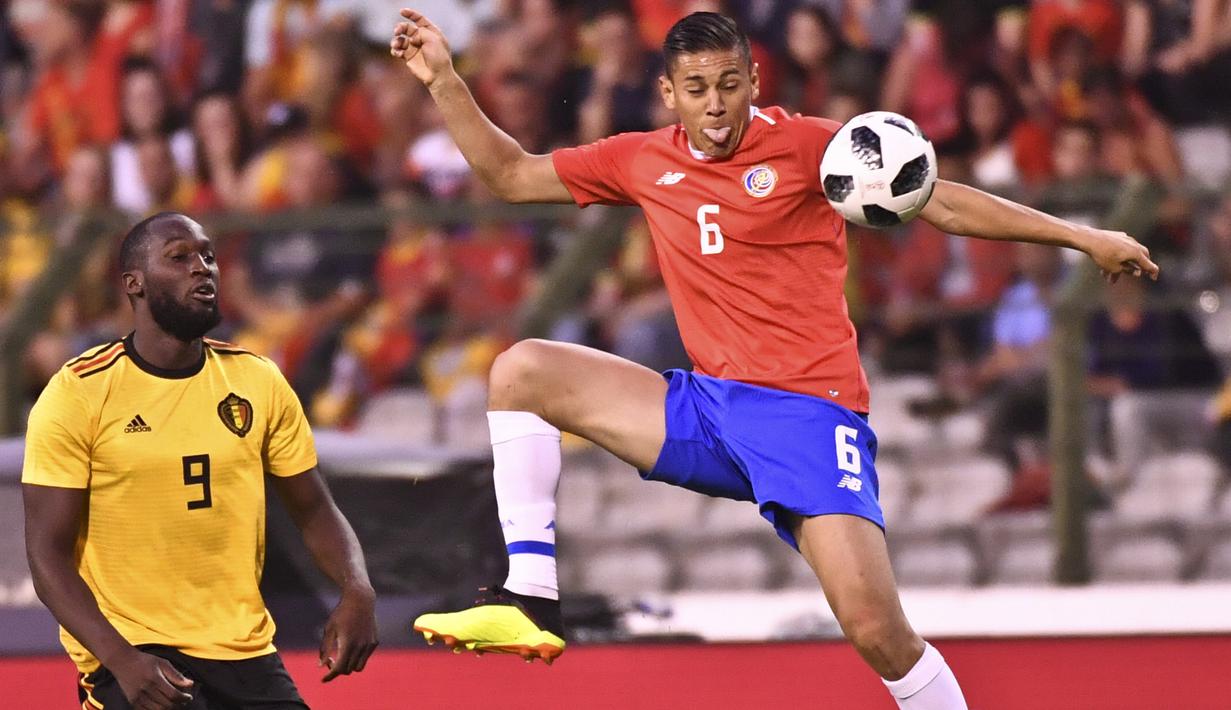 Pemain Kosta Rika, Oscar Duarte mengontrol bola dari kejaran pemain Belgia, Romelu Lukaku pada laga uji coba di King Baudouin stadium, Brussels, (11/6/2018). Belgia menang 4-1. (AP/Geert Vanden Wijngaert)