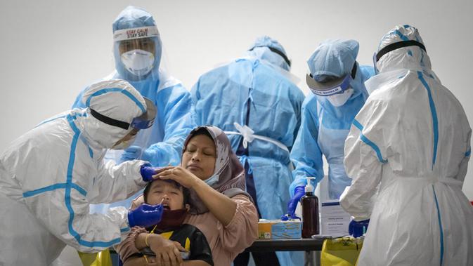 Petugas melakukan uji COVID-19 terhadap warga di Bandar Utama, Kuala Lumpur, Malaysia, Kamis (22/10/2020). Mulai 21 Oktober 2020, Malaysia membatasi pergerakan di Kuala Lumpur, Selangor, dan Putrajaya untuk mengekang peningkatan tajam kasus COVID-19. (AP Photo/Vincent Thian)