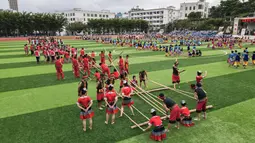 Para pelajar mengikuti kompetisi tari bambu di Sekolah Menengah Baoting di Wilayah Otonom Etnis Li dan Miao Baoting, Provinsi Hainan, China pada 18 November 2020. Sebagai bagian dari festival seni Sekolah Menengah Baoting, sebuah kompetisi tari bambu digelar pada Rabu (18/11). (Xinhua/Zhang Liyun)