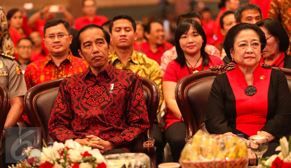 Presiden Jokowi duduk di samping Ketum PDIP Megawati Soekarnoputri berbincang pada peringatan HUT PDIP ke-44 di JCC, Jakarta Pusat, Selasa (10/1). HUT PDI Perjuangan ke-44 ini juga dihadiri sejumlah menteri kabinet kerja. (Liputan6.com/Faizal Fanani)