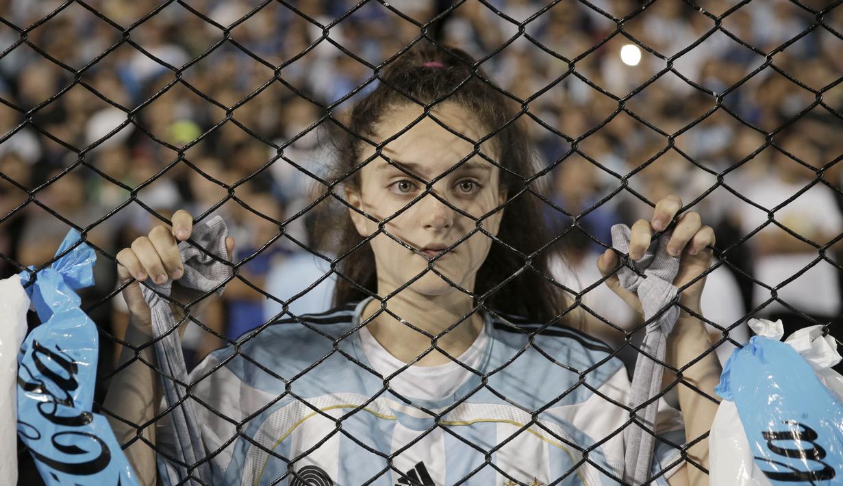 Seorang suporter cantik Argentina kecewa atas hasil imbang timnya melawan Peru pada laga Kualifikasi Piala Dunia 2018 di Buenos Aires, (5/10/2017). Argentina bermain imbang 0-0 lawan Peru. (AP/Natacha Pisarenko)