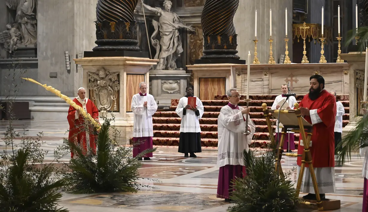 Paus Fransiskus memegang ranting pohon palem saat memimpin Misa Minggu Palma di St. Peter's Basilica, Vatikan, Minggu (5/4/2020). Misa hanya diikuti sejumlah petugas yang tetap menjaga jarak untuk menghindari penyebaran virus corona COVID-19. (AP Photo/pool/Alberto Pizzoli)